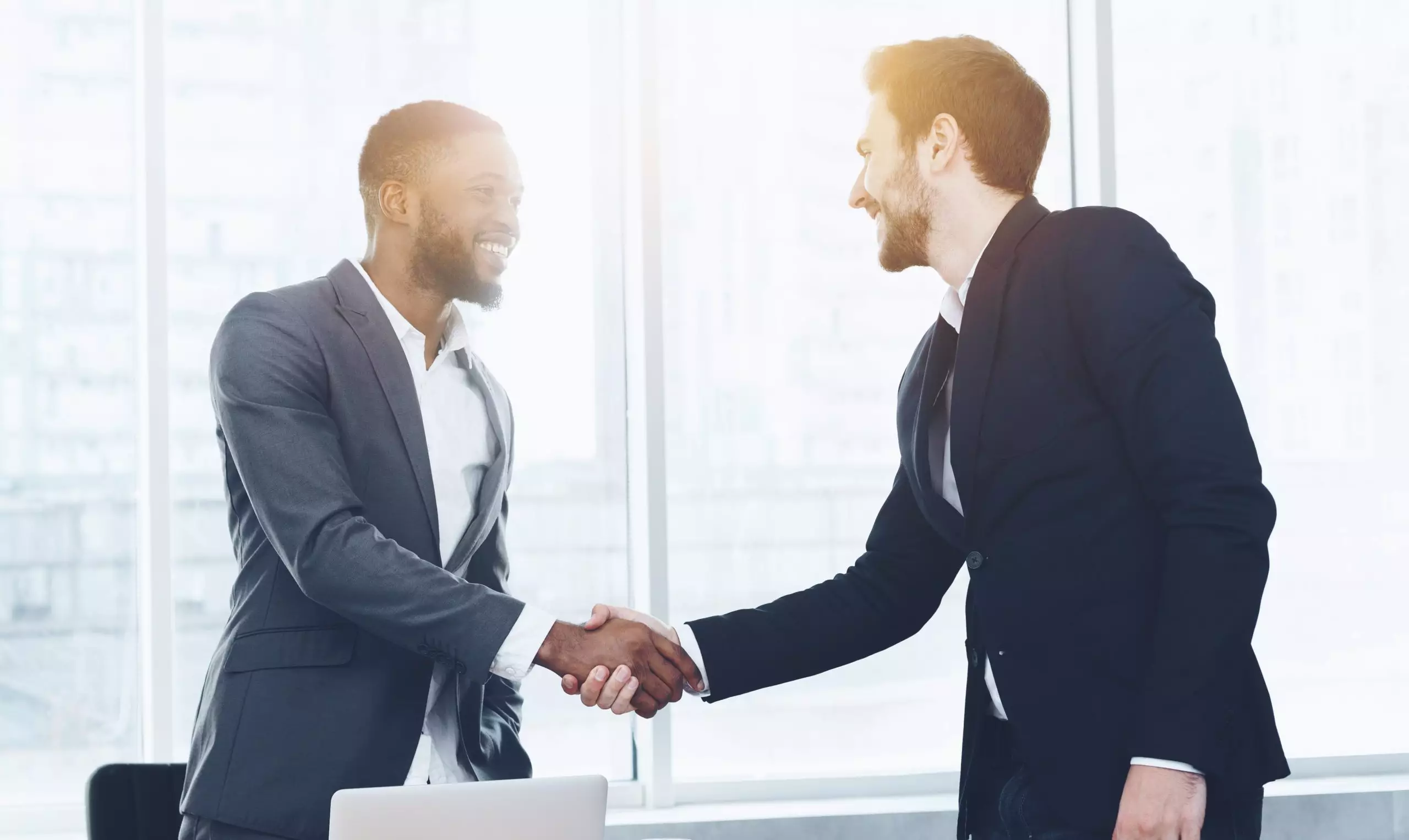 Business men shaking hands smiling